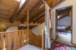 This charming property features a cozy attic space with exposed wooden beams and a unique wooden railing.