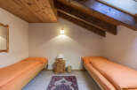 This charming bedroom features two single beds with vibrant orange bedding, perfect for a cozy stay.