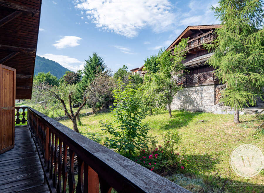 This property boasts stunning views from a private balcony overlooking lush greenery and a charming garden.