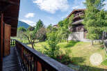 This property boasts stunning views from a private balcony overlooking lush greenery and a charming garden.