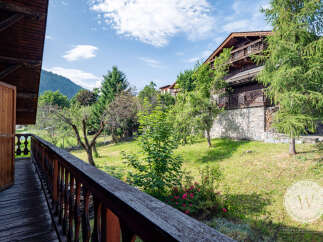 This property boasts stunning views from a private balcony overlooking lush greenery and a charming garden.