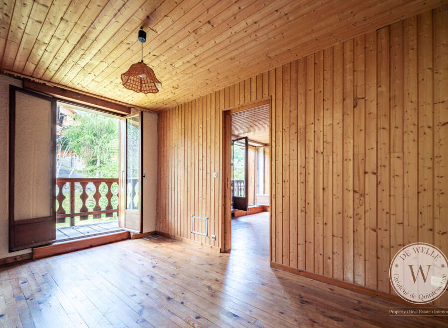 Discover this charming room featuring warm wood paneling on the walls and ceiling, complemented by beautiful hardwood floors.
