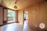 Discover this charming room featuring warm wood paneling on the walls and ceiling, complemented by beautiful hardwood floors.