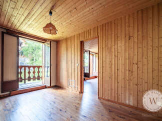 Discover this charming room featuring warm wood paneling on the walls and ceiling, complemented by beautiful hardwood floors.