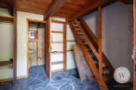 This unique property showcases rustic charm with its wooden ceiling, beams, and staircase.