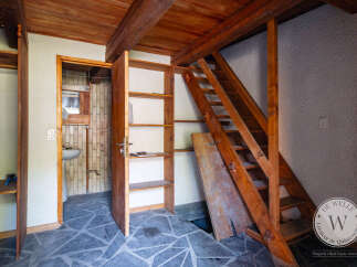 This unique property showcases rustic charm with its wooden ceiling, beams, and staircase.