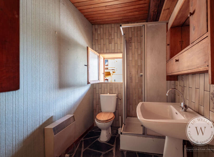 This bathroom features a compact design with an open window above the toilet, providing natural light and ventilation.