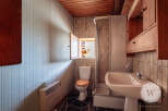 This bathroom features a compact design with an open window above the toilet, providing natural light and ventilation.