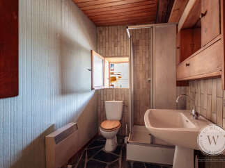 This bathroom features a compact design with an open window above the toilet, providing natural light and ventilation.