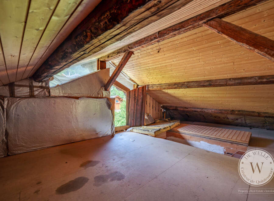 Discover the untapped potential of this attic space with its exposed wooden beams and unique architectural details.