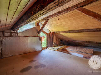 Discover the untapped potential of this attic space with its exposed wooden beams and unique architectural details.