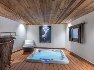 Indulge in the ultimate relaxation in this stunning spa room, featuring a luxurious hot tub, rustic wood accents, and a captivating deer art piece.