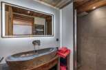 This bathroom features a rustic-chic design with a stone vessel sink atop a reclaimed wood vanity.