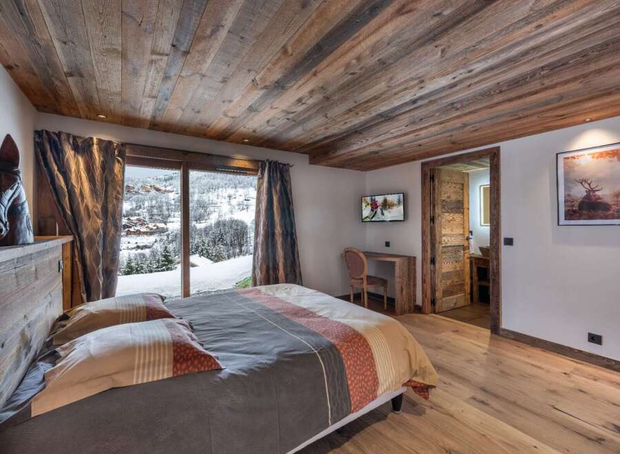 Experience luxury in this bedroom featuring a wooden ceiling and floor, creating a warm and inviting ambiance.
