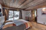 Experience luxury in this bedroom featuring a wooden ceiling and floor, creating a warm and inviting ambiance.