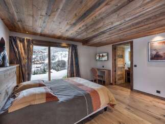 Experience luxury in this bedroom featuring a wooden ceiling and floor, creating a warm and inviting ambiance.