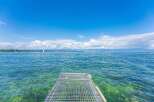 This is a picturesque view of a metal pier extending into a serene body of water.