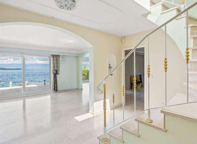 Experience luxury living in this stunning home featuring a grand foyer with a curved staircase and elegant marble flooring.