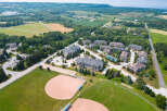 This aerial view showcases a beautifully landscaped real estate development nestled in a vibrant community, complete with well-maintained baseball fields and lush greenery.