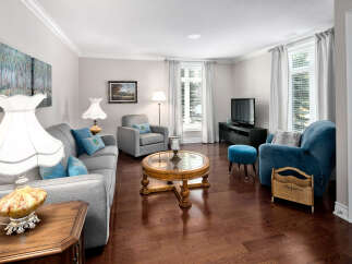 This elegant living room boasts hardwood floors, neutral paint, and stylish furnishings, creating a warm and inviting atmosphere.