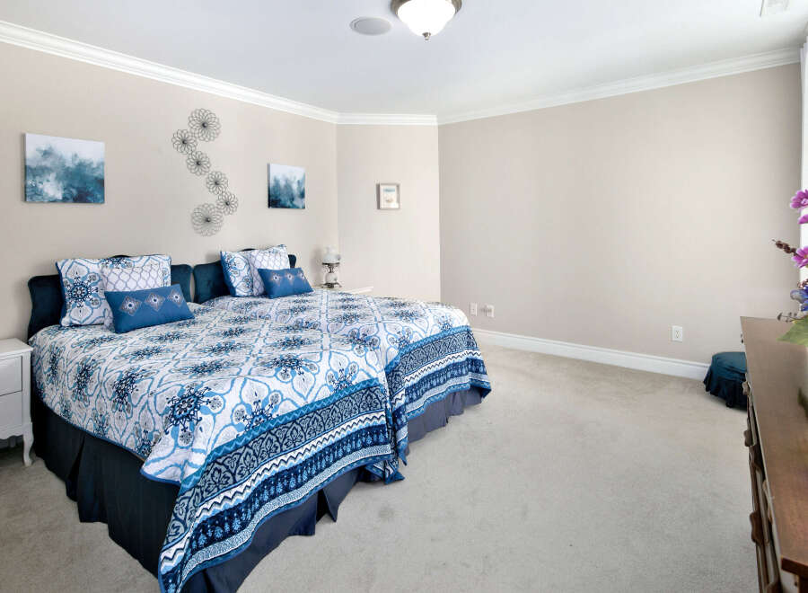 This bedroom features a harmonious blend of comfort and style, boasting soft carpeting and neutral walls that create a serene atmosphere.