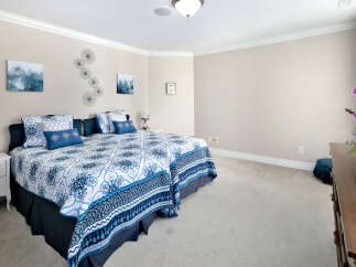 This bedroom features a harmonious blend of comfort and style, boasting soft carpeting and neutral walls that create a serene atmosphere.