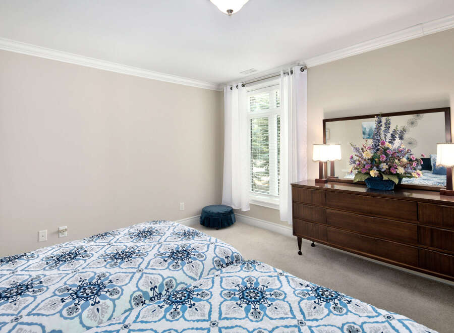 This bedroom features a serene ambiance with its neutral wall paint and soft carpet, perfect for relaxation.