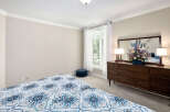 This bedroom features a serene ambiance with its neutral wall paint and soft carpet, perfect for relaxation.