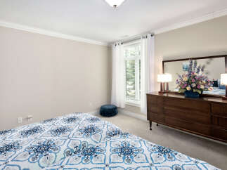 This bedroom features a serene ambiance with its neutral wall paint and soft carpet, perfect for relaxation.