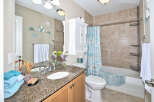 This bathroom boasts a beach-inspired theme with seashell decorations and a coordinating shower curtain.