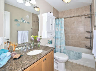 This bathroom boasts a beach-inspired theme with seashell decorations and a coordinating shower curtain.