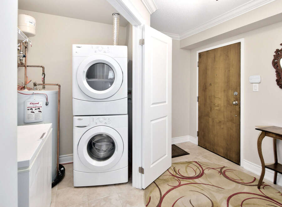 This laundry room features a stacked washer and dryer unit for space-saving efficiency.