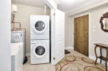 This laundry room features a stacked washer and dryer unit for space-saving efficiency.