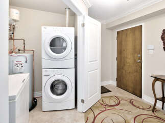 This laundry room features a stacked washer and dryer unit for space-saving efficiency.