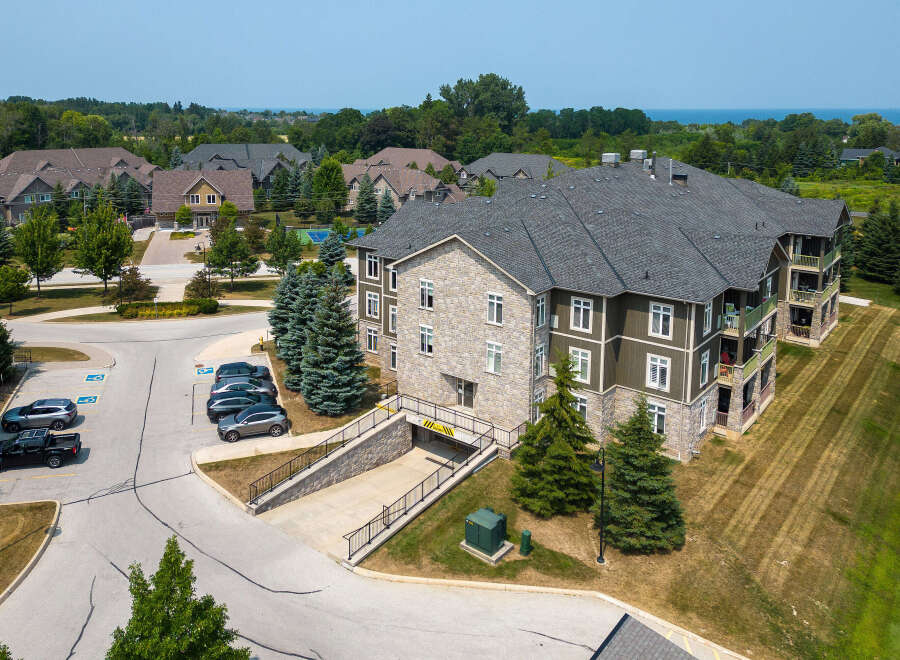 Discover the charm of this multi-story condo building featuring a blend of stone and wood siding, complemented by balconies with scenic views.