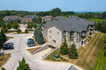 Discover the charm of this multi-story condo building featuring a blend of stone and wood siding, complemented by balconies with scenic views.