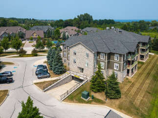 Discover the charm of this multi-story condo building featuring a blend of stone and wood siding, complemented by balconies with scenic views.