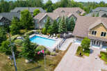 This aerial shot showcases a residential community with a sparkling blue swimming pool as its centerpiece.