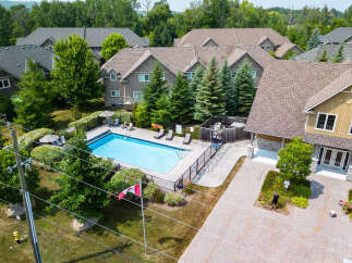 This aerial shot showcases a residential community with a sparkling blue swimming pool as its centerpiece.
