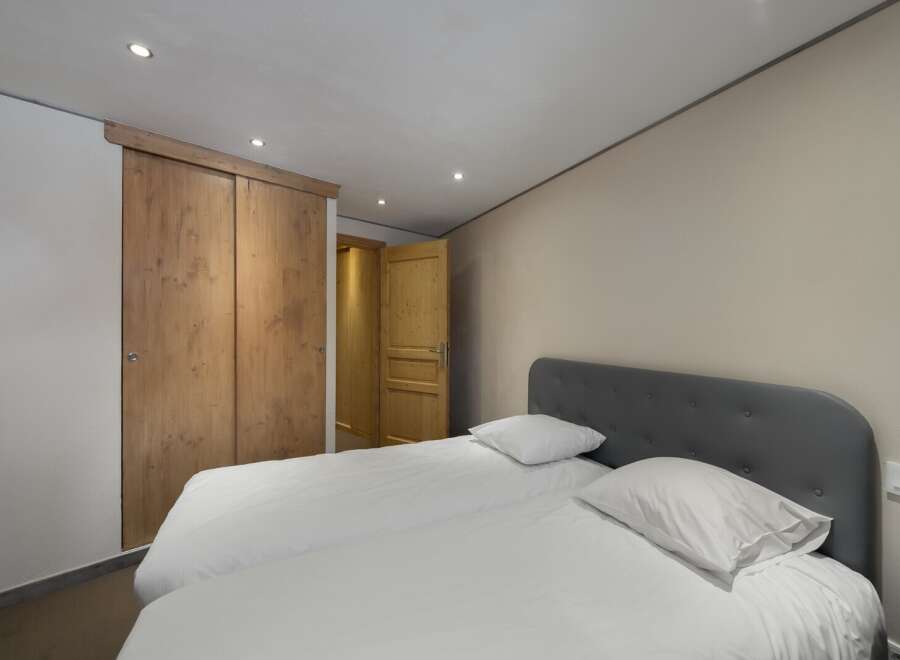This cozy bedroom features a comfortable bed with fresh white linens, perfect for a relaxing stay.