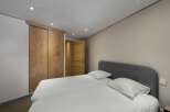 This cozy bedroom features a comfortable bed with fresh white linens, perfect for a relaxing stay.
