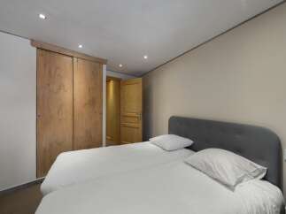This cozy bedroom features a comfortable bed with fresh white linens, perfect for a relaxing stay.