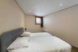 This cozy bedroom features two twin beds with crisp white linens, perfect for guests or a shared living space.