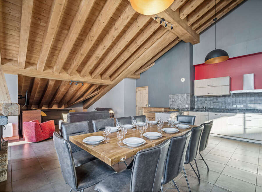 Experience luxury living in this stunning property, featuring a spacious dining area with a rustic wooden table and stylish seating.