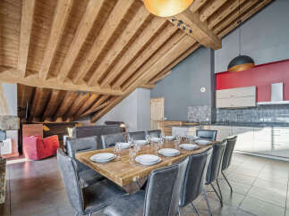 Experience luxury living in this stunning property, featuring a spacious dining area with a rustic wooden table and stylish seating.