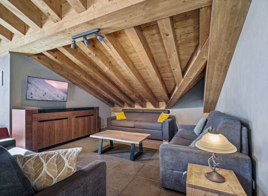 Discover the charm of this stunning property, featuring a cozy living room with a unique wooden ceiling.