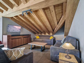 Discover the charm of this stunning property, featuring a cozy living room with a unique wooden ceiling.