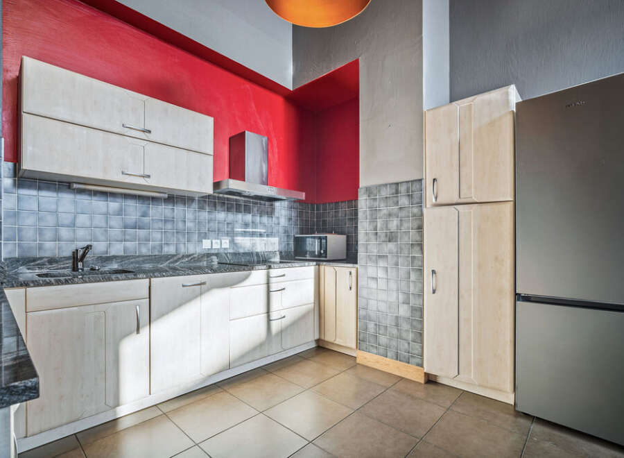 This modern kitchen boasts sleek cabinetry and a stainless steel refrigerator, perfect for culinary enthusiasts.