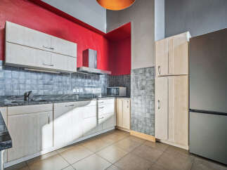 This modern kitchen boasts sleek cabinetry and a stainless steel refrigerator, perfect for culinary enthusiasts.