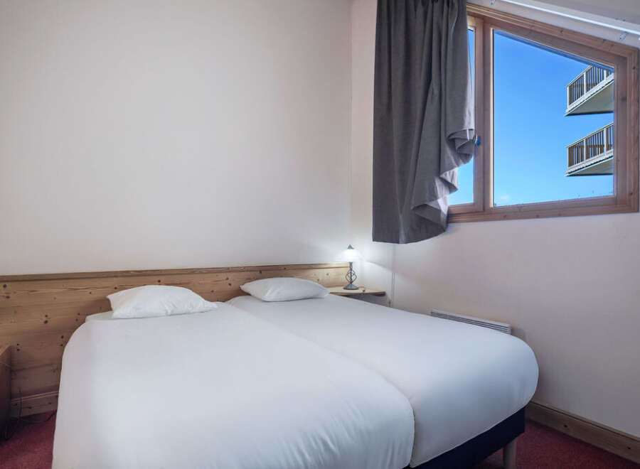 This cozy bedroom features two twin beds, perfect for guests or roommates.